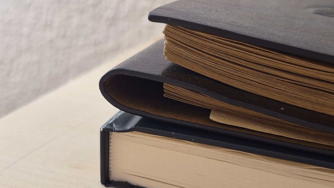 Conservator's hands performing detailed bookbinding stitching work
